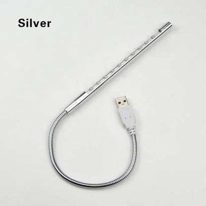 Spiral-shaped silver aluminium alloy USB LED desk lamp on a wooden table.