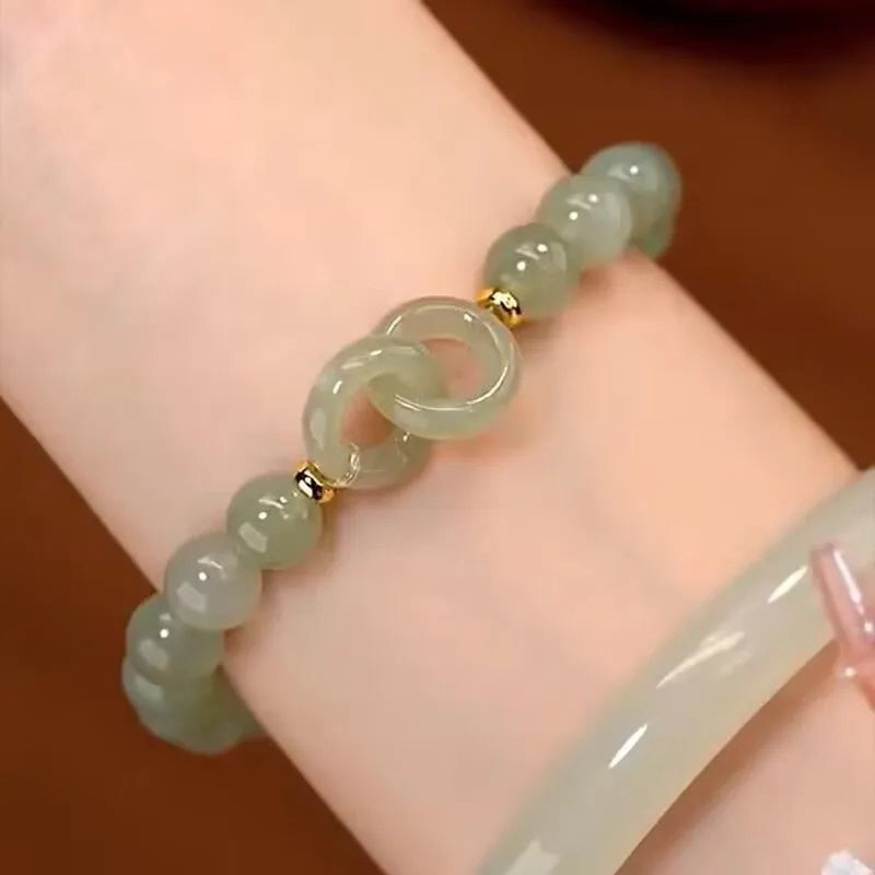 Chinese style glass bead bracelet with bamboo joint design on wrist.