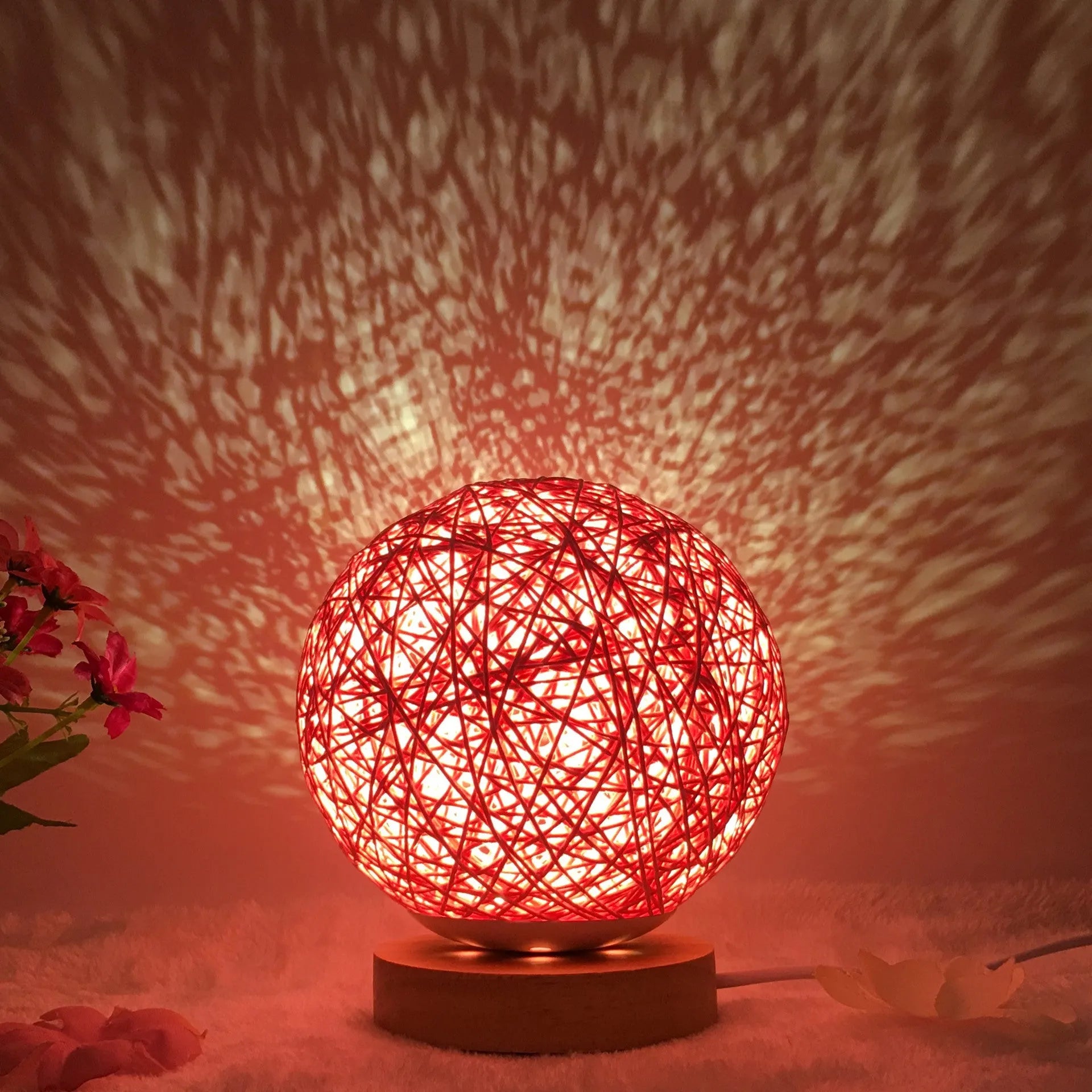 Spherical hand-knitted rattan table lamp with remote control on a wooden desk