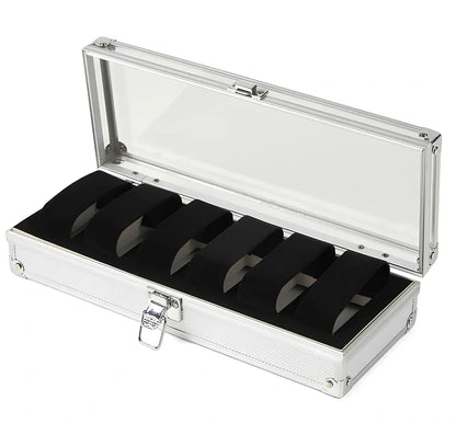 Aluminium watch storage box with clear lid showing six velvet-lined compartments for watch collection