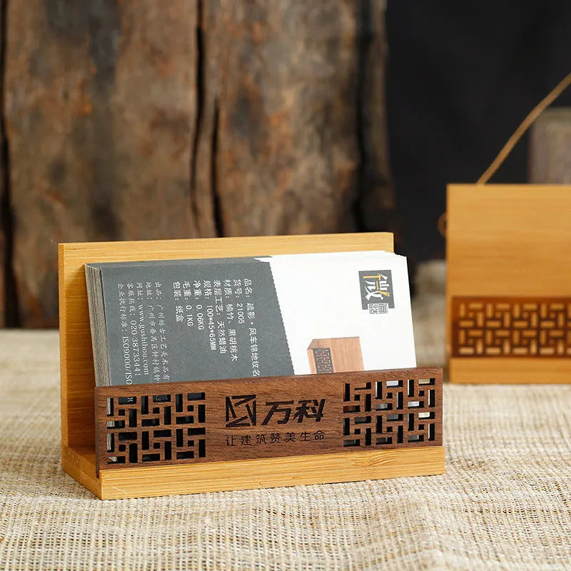 Geometric bamboo and black walnut wood business card holder on a desk.