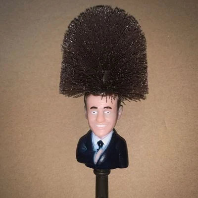 Comical Donald Trump-themed toilet brush made of durable plastic with a bold yellow color and convenient hanging slot