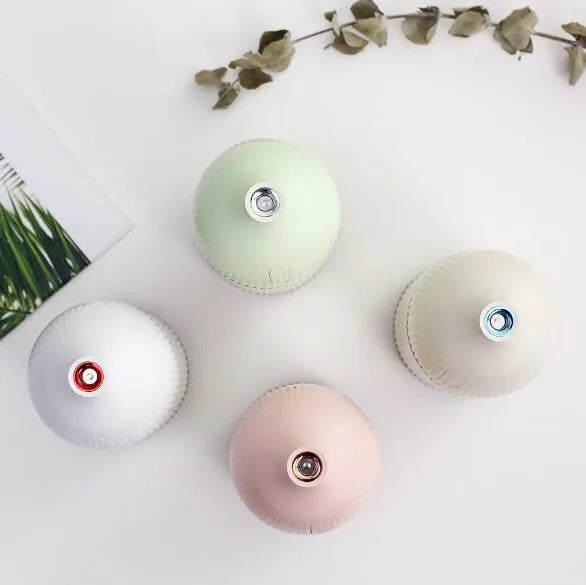 White USB-powered ultrasonic aromatherapy diffuser and humidifier with 300ml bottle and LED light on a desk.