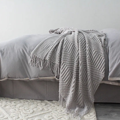 Small grey polyester fibre nap blanket folded, showing dimensions of 127 cm by 170 cm.