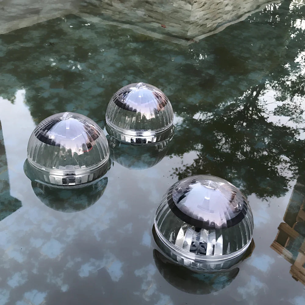 Solar-powered floating pool lights with colour-changing LEDs on water surface