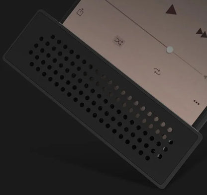 Portable black ABS plastic phone amplifier bracket holding a smartphone on a desk.