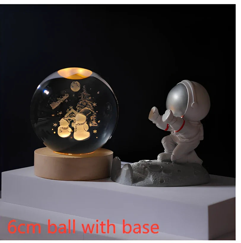 3D crystal ball night light projecting solar system pattern on wooden base with astronaut figurine