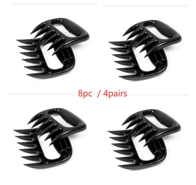 Two black bear claw meat shredders with decorative handles on a kitchen surface.