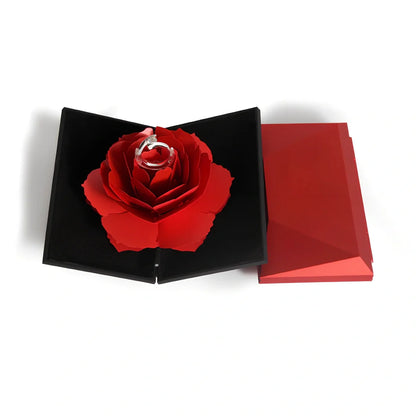 Rotating ring box with embossed paper exterior showing 360-degree mechanism and flannel interior