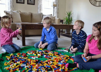 A large, waterproof travel picnic mat made of durable nylon with convenient toy storage bags for outdoor adventures.