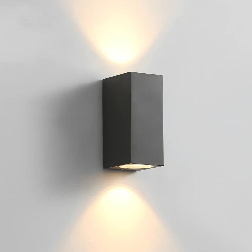 Black aluminium LED wall lamp with tempered glass shade mounted on white wall