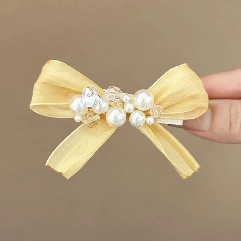 Yellow bow hair barrette clip with rhinestone pearl detail on duckbill clip base