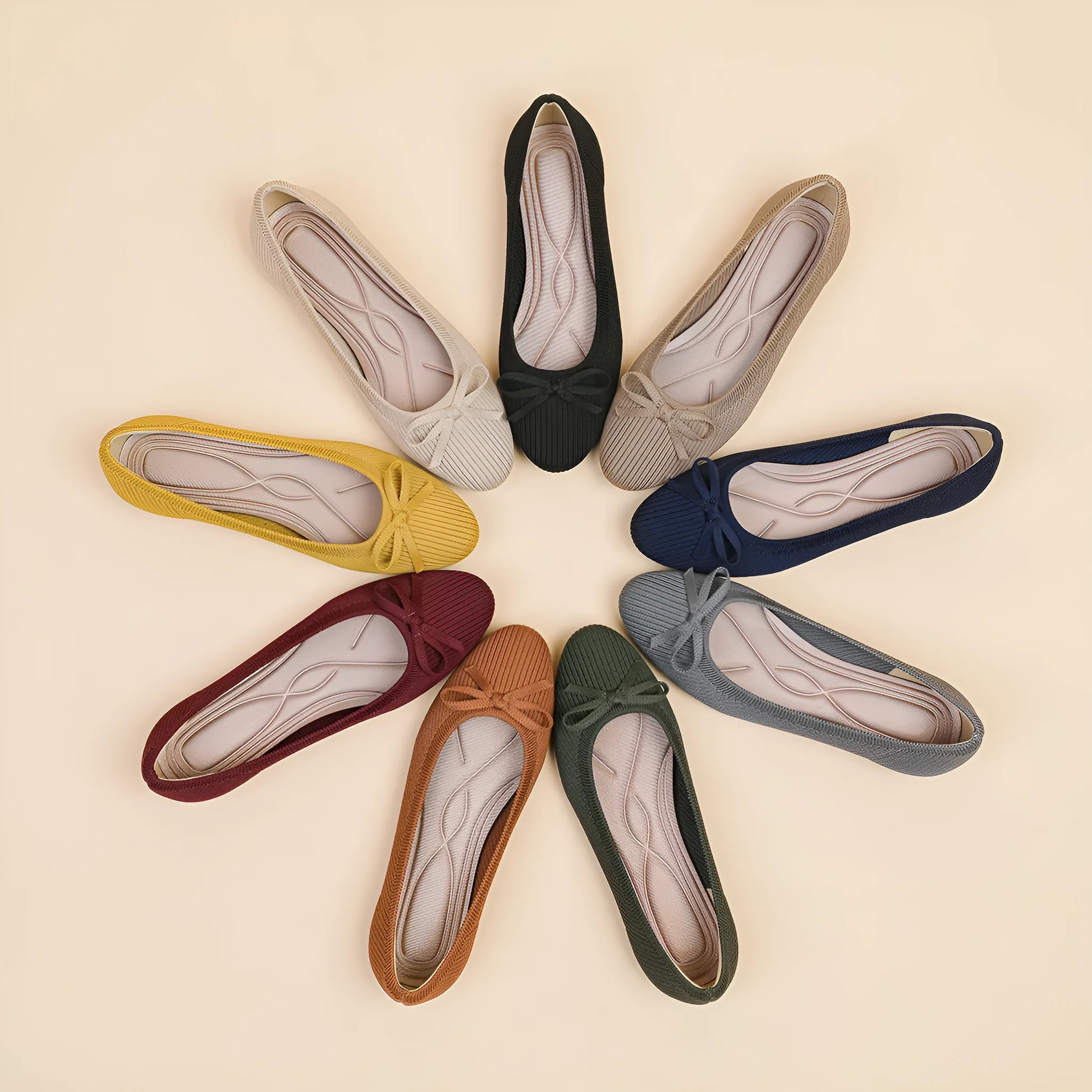 Women's black fabric flat pumps with a bow detail on the round toe, shown on a white background.