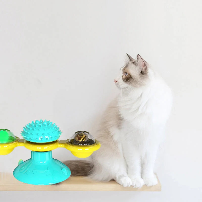Cat playing with rotating windmill toy featuring suction base and luminous ball