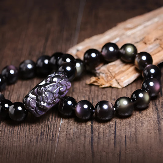 Natural Icy Obsidian crystal Pi Xiu bracelet with polished beads in ethnic geometric style.