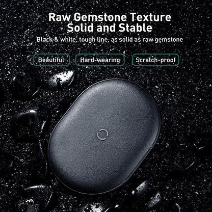 Black Baseus 15W wireless charging pad with textured silicone surface on a wooden desk.