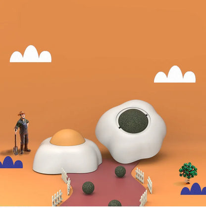Interactive plush catnip ball toy shaped like a fried egg, stuck to a wall with a cat batting at it.