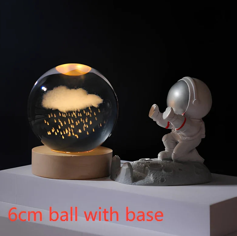 3D crystal ball night light projecting solar system pattern on wooden base with astronaut figurine