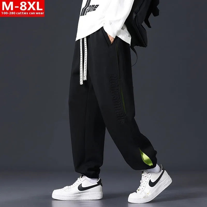 Men's ankle banded trousers in micro-elastic cotton with collage stitching details, showing loose fit and tapered leg