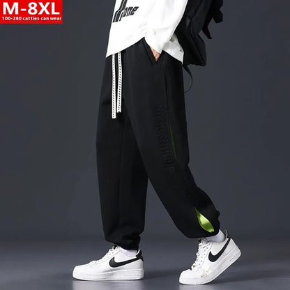 Men's ankle banded trousers in micro-elastic cotton with collage stitching details, showing loose fit and tapered leg