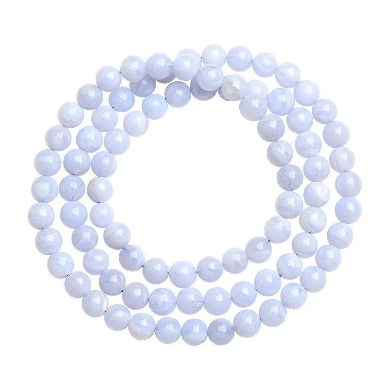 Blue agate bracelet with 6-6.8mm beads in multi-circle pattern and Ruyi elements on a wrist.