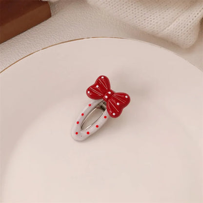 Red plastic hair clip with a 3D love heart and dots on a willow leaf-shaped base.