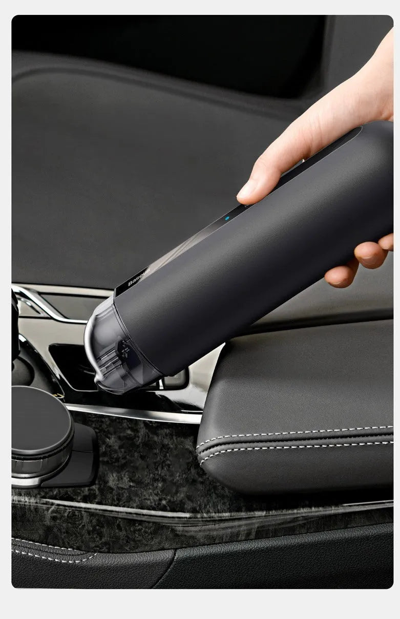 BASEUS handheld car vacuum cleaner in black with blowing hose attachment, showing compact size and dust bin
