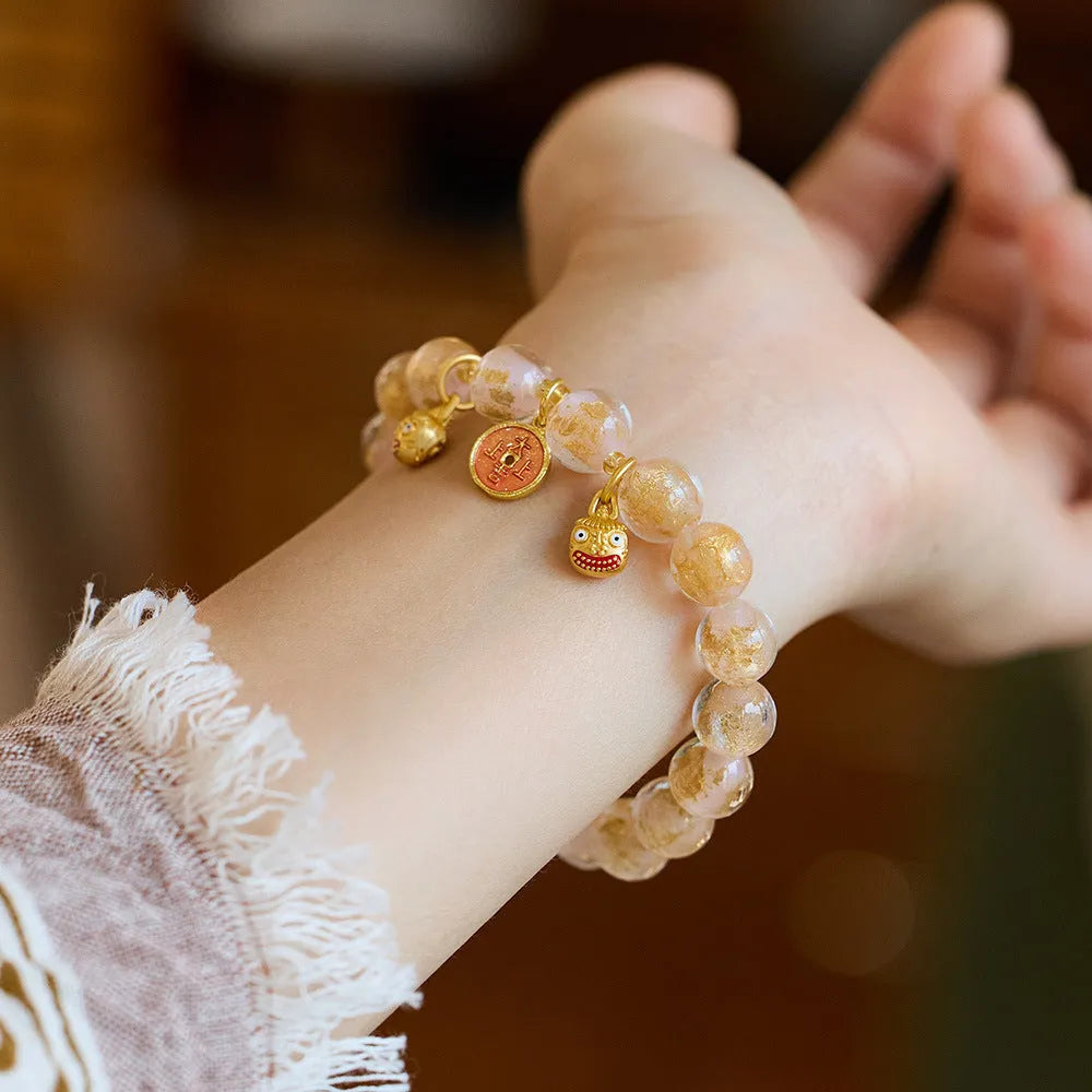 Handmade national style bracelet with coloured glaze swallowing gold beast charm on beaded band.