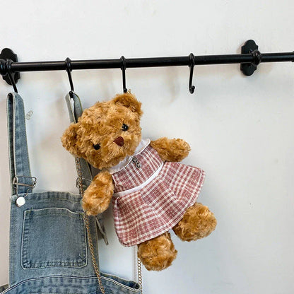 A plush teddy bear crossbody messenger bag with an adjustable shoulder strap and a zippered interior pocket for convenient storage.