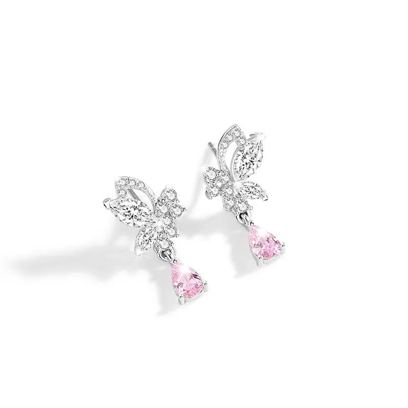Butterfly shaped silver stud earrings with crystal details on white background