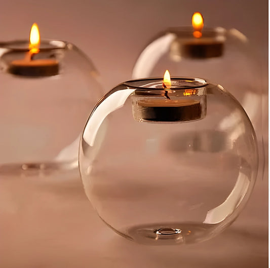 Handmade round hollow glass candle holder in three sizes on a table.