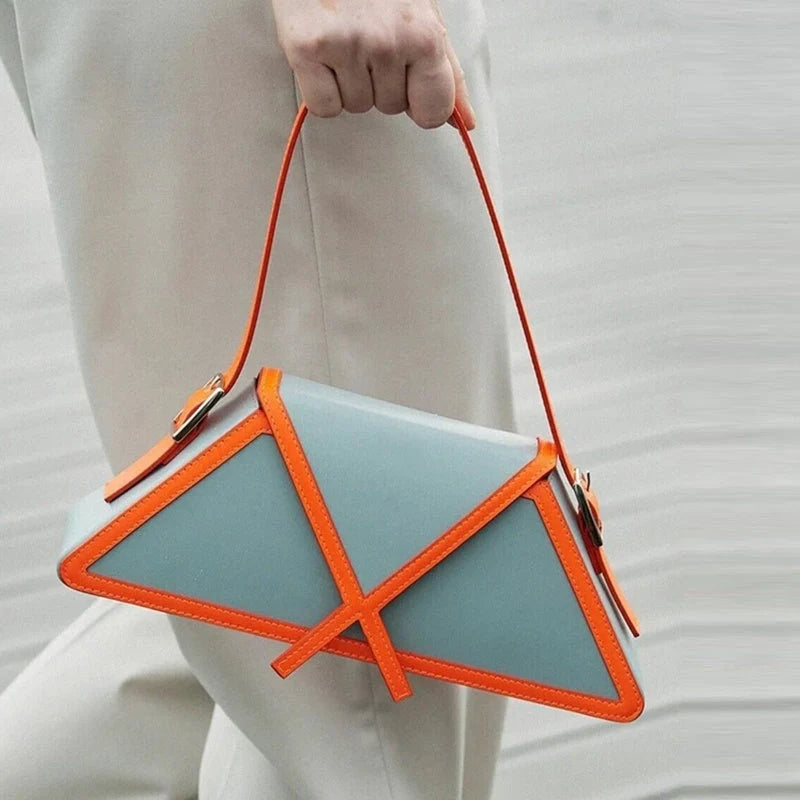 Stitching contrast trapezoid shoulder bag in black, beige, blue, and orange with magnetic buckle closure