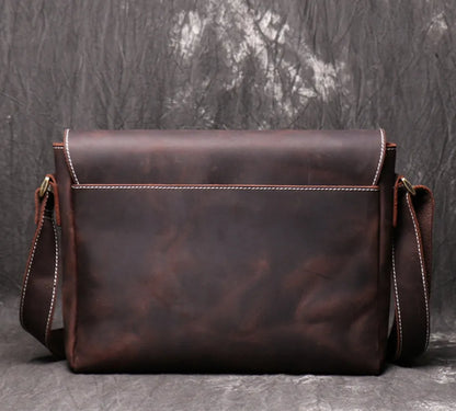 Vintage brown leather mens messenger bag with flap open, showing internal phone pouch and zipper pocket.