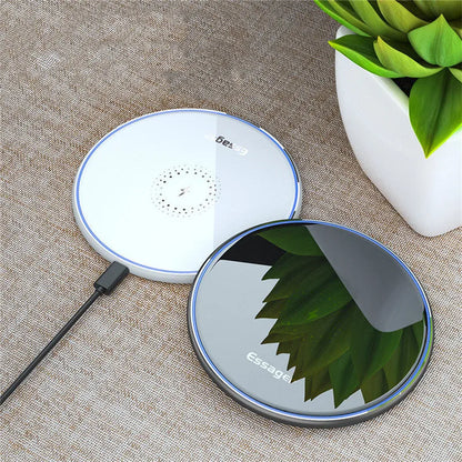 Black wireless charger on table with phone charging, showing blue LED light and anti-slip surface