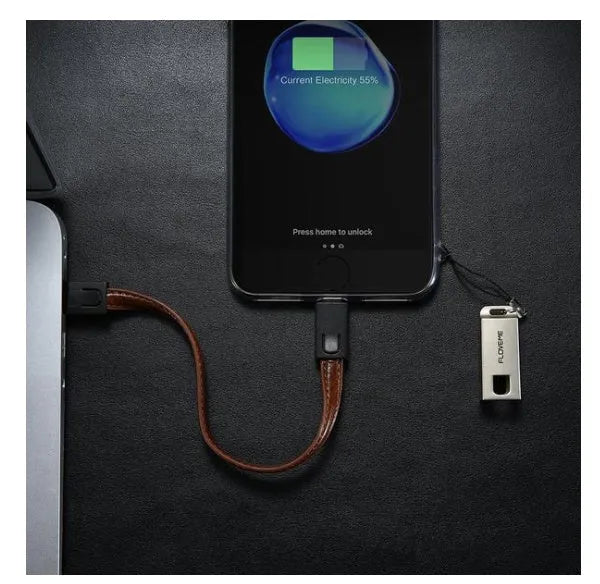 Short black leather iPhone charging cable with metal connector next to a power bank