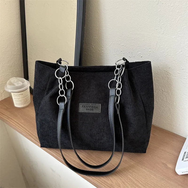 Corduroy tote handbag for women with one-shoulder design, large capacity, medium-soft texture, and street-trend style available in black, brown, or white for daily configuration