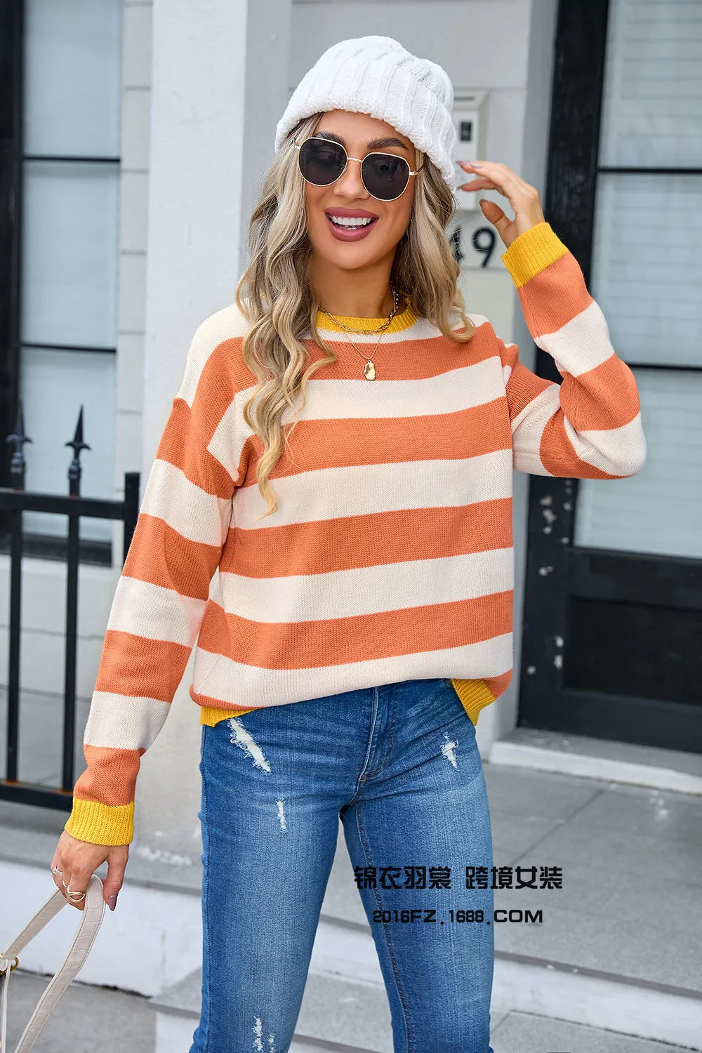 Women's loose fit striped long sleeve round neck sweater on a hanger.