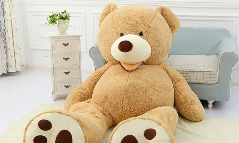 A giant, plush teddy bear in a variety of sizes and colors, including light brown, dark brown, gray, white, pink, and purple.