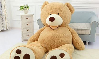 A giant, plush teddy bear in a variety of sizes and colors, including light brown, dark brown, gray, white, pink, and purple.