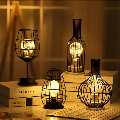 Minimalist hollow table lamp in red wine bottle design with wrought iron construction and warm white LED illumination