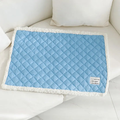 Quilted terry cloth pet blanket for cats in blue, grey, pink, or yellow colour on a pet bed.