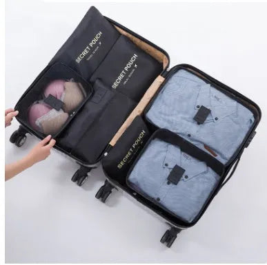 Set of six coloured nylon packing cubes and flat pouches for travel organisation.