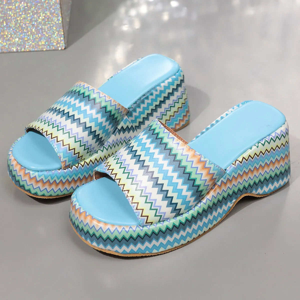 Women's beige wedge sandals with a blue wave print, thick rubber sole, and open fish mouth toe.