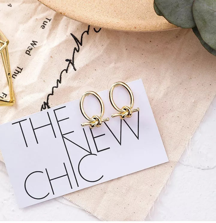 Gold alloy stud earrings with oval knotted design