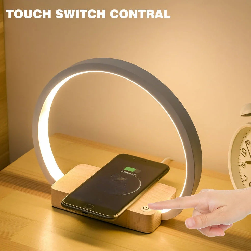 White wireless charging table lamp with metal shade and button switch on wooden surface