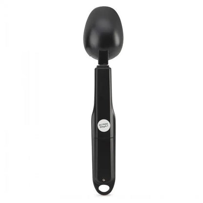Smart digital measuring spoon with electronic display showing weight, alongside two AAA batteries.