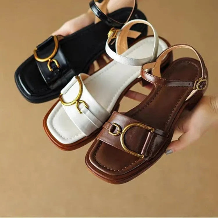 Women's black leather sandals with a thick rubber sole and button fastening on a round toe.