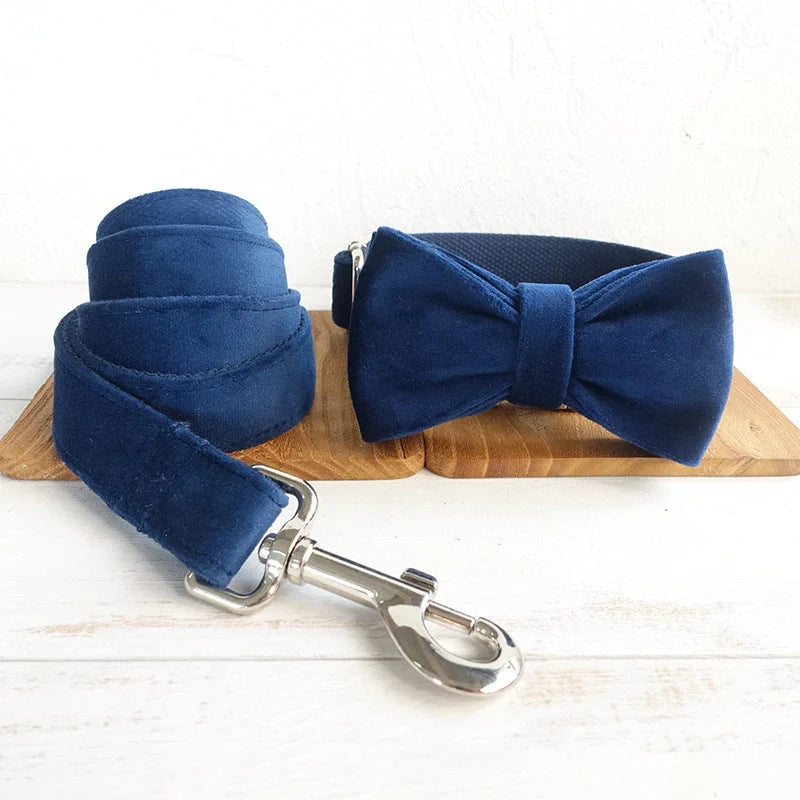 A stylish dark blue velvet pet collar with a matching bow tie accessory, perfect for dressing up your dog