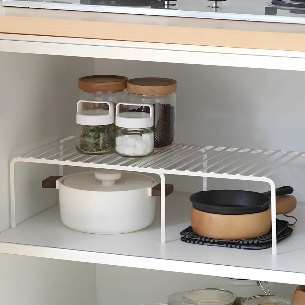 White retractable kitchen shelf extended to 60cm with spices and oils organised on metal surface
