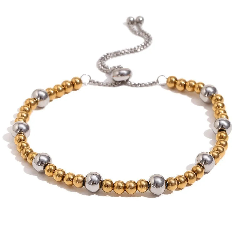 Gold electroplated stainless steel earrings, necklace, and bracelet set with geometric shapes and round ring elements
